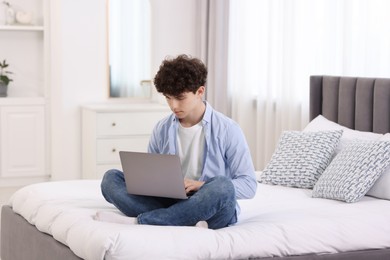 Teenager working with laptop on bed at home. Remote job