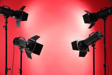 Photo of Red photo background and professional lighting equipment in studio