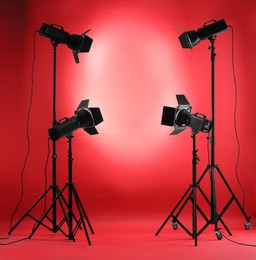 Photo of Red photo background and professional lighting equipment in studio