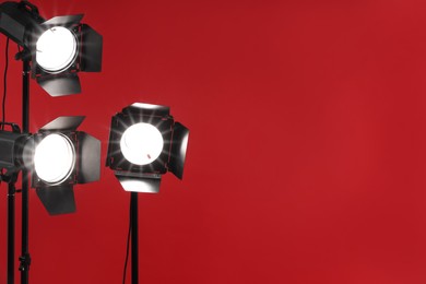 Photo of Red photo background and professional lighting equipment in studio, space for text