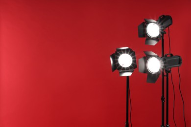 Photo of Red photo background and professional lighting equipment in studio, space for text