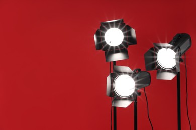 Photo of Red photo background and professional lighting equipment in studio, space for text