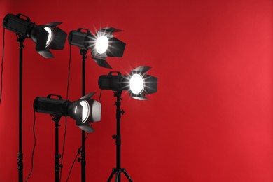 Photo of Red photo background and professional lighting equipment in studio, space for text