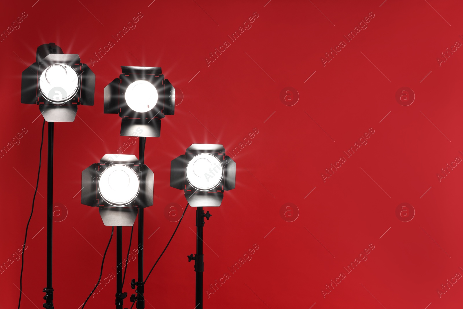 Photo of Red photo background and professional lighting equipment in studio, space for text