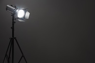 Photo of Dark photo background and professional lighting equipment in studio, space for text