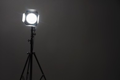 Photo of Dark photo background and professional lighting equipment in studio, space for text