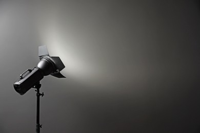 Dark photo background and professional lighting equipment in studio, space for text