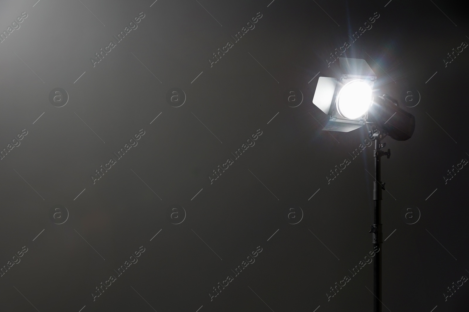 Photo of Dark photo background and professional lighting equipment in studio, space for text