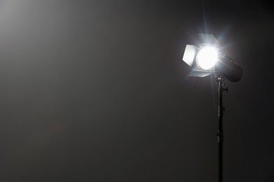 Dark photo background and professional lighting equipment in studio, space for text