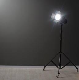 Dark photo background and professional lighting equipment in studio, space for text