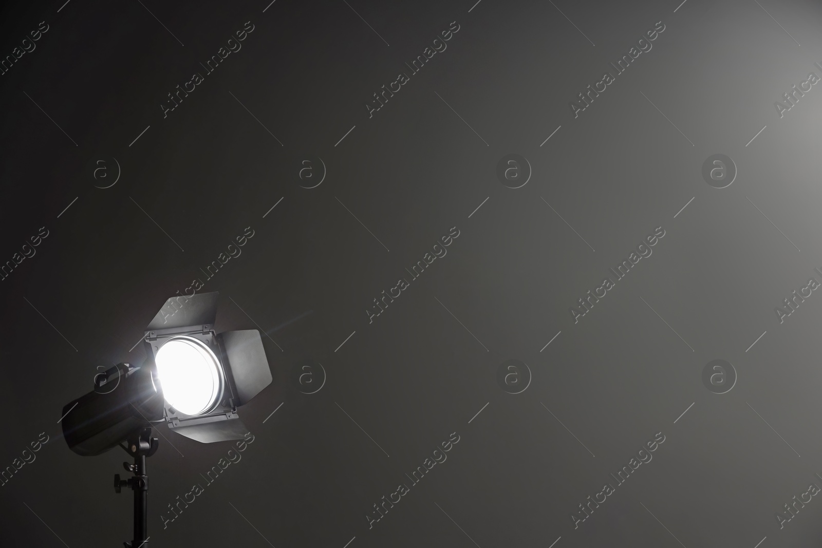 Photo of Dark photo background and professional lighting equipment in studio, space for text