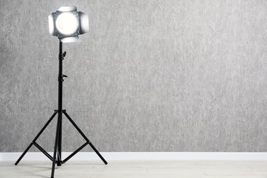 Photo of Grey photo background and professional lighting equipment in studio, space for text