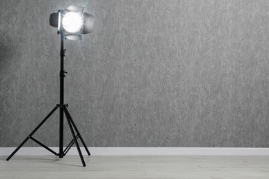 Grey photo background and professional lighting equipment in studio, space for text