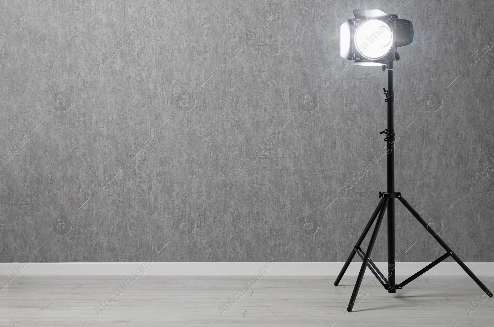 Photo of Grey photo background and professional lighting equipment in studio, space for text