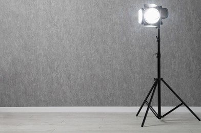 Grey photo background and professional lighting equipment in studio, space for text