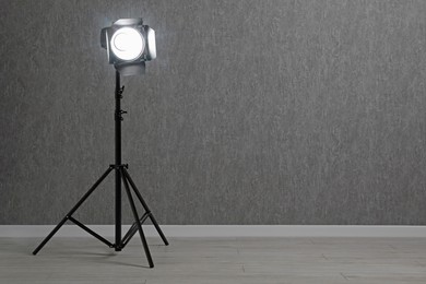 Grey photo background and professional lighting equipment in studio, space for text