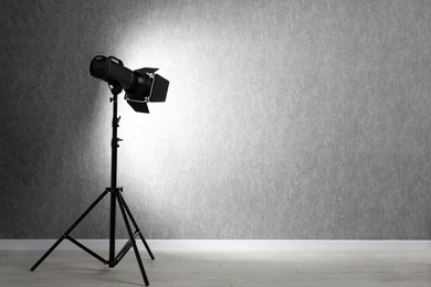 Photo of Grey photo background and professional lighting equipment in studio, space for text