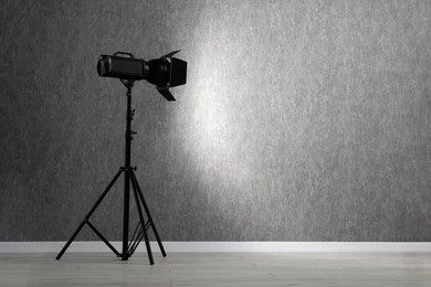 Photo of Grey photo background and professional lighting equipment in studio, space for text