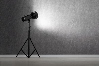 Grey photo background and professional lighting equipment in studio, space for text