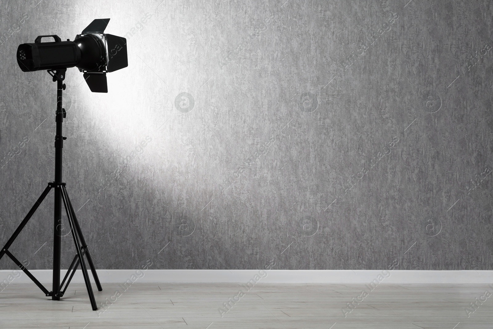 Photo of Grey photo background and professional lighting equipment in studio, space for text