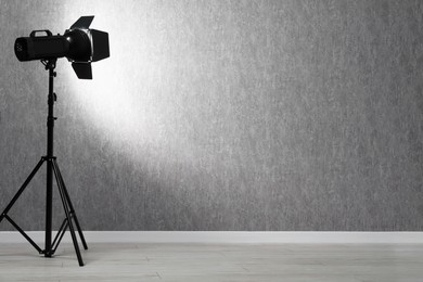 Grey photo background and professional lighting equipment in studio, space for text