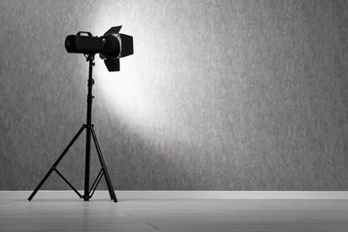 Grey photo background and professional lighting equipment in studio, space for text