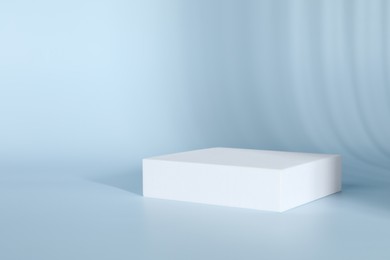 Photo of Presentation of product. White podium on light blue background. Space for text