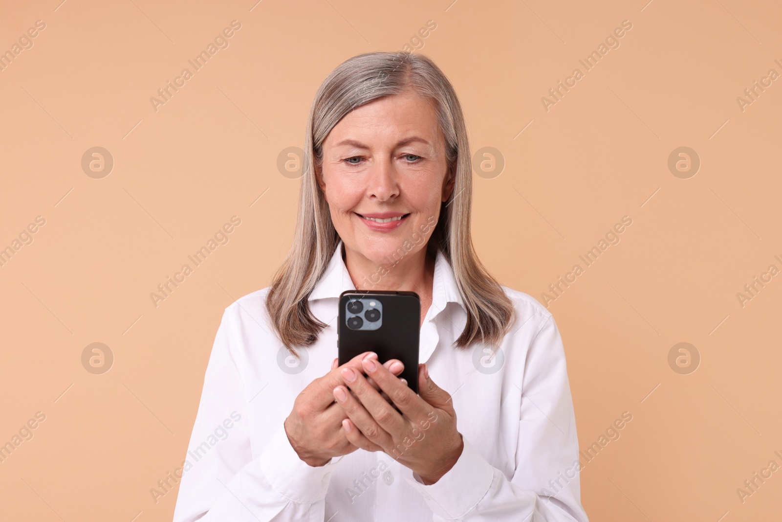 Photo of Senior woman with phone on beige background