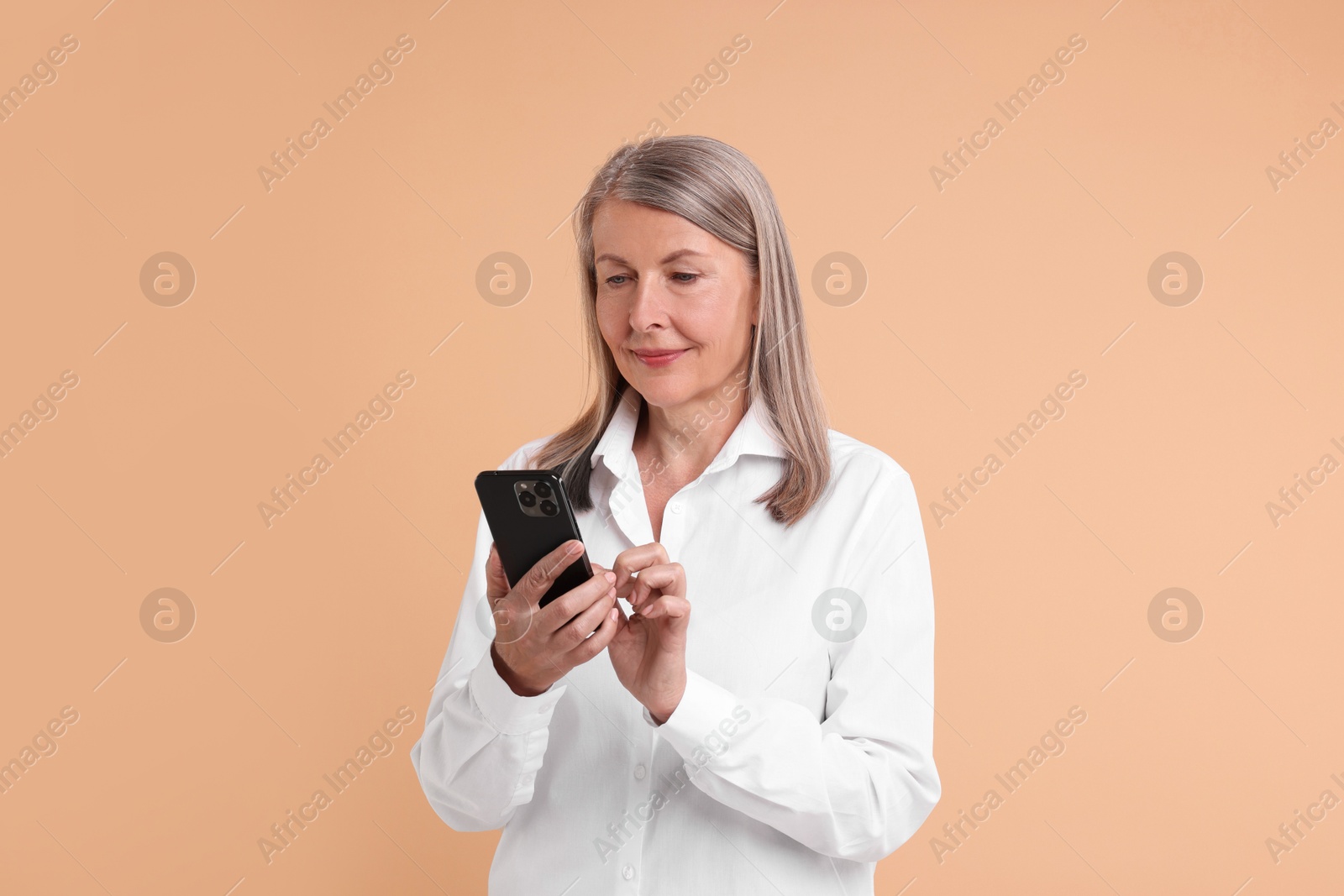 Photo of Senior woman with phone on beige background