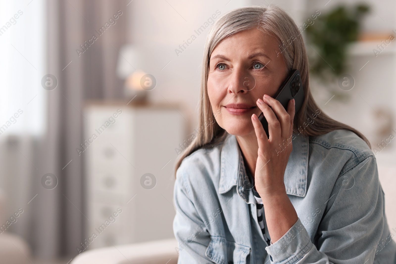 Photo of Senior woman talking on phone at home, space for text