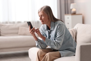 Senior woman using mobile phone at home