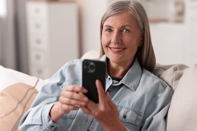 Senior woman using mobile phone at home