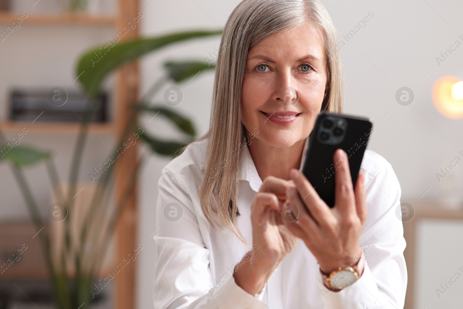 Photo of Senior woman using mobile phone at home