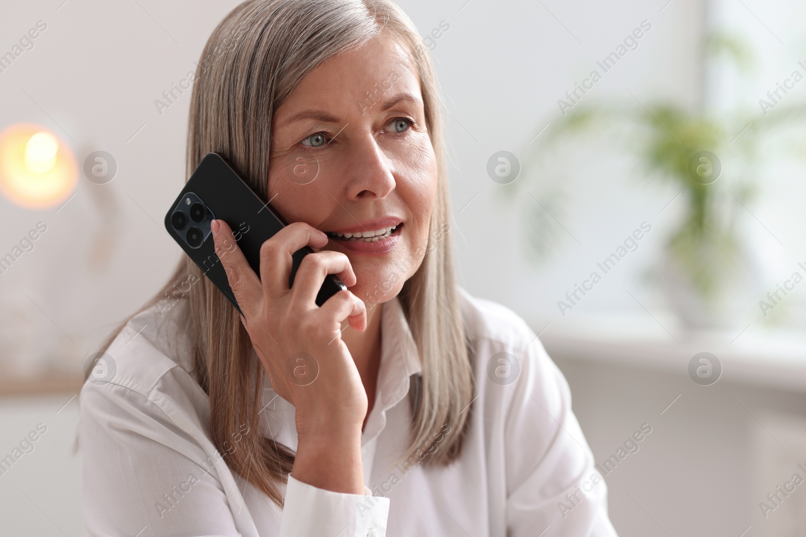 Photo of Senior woman talking on phone at home