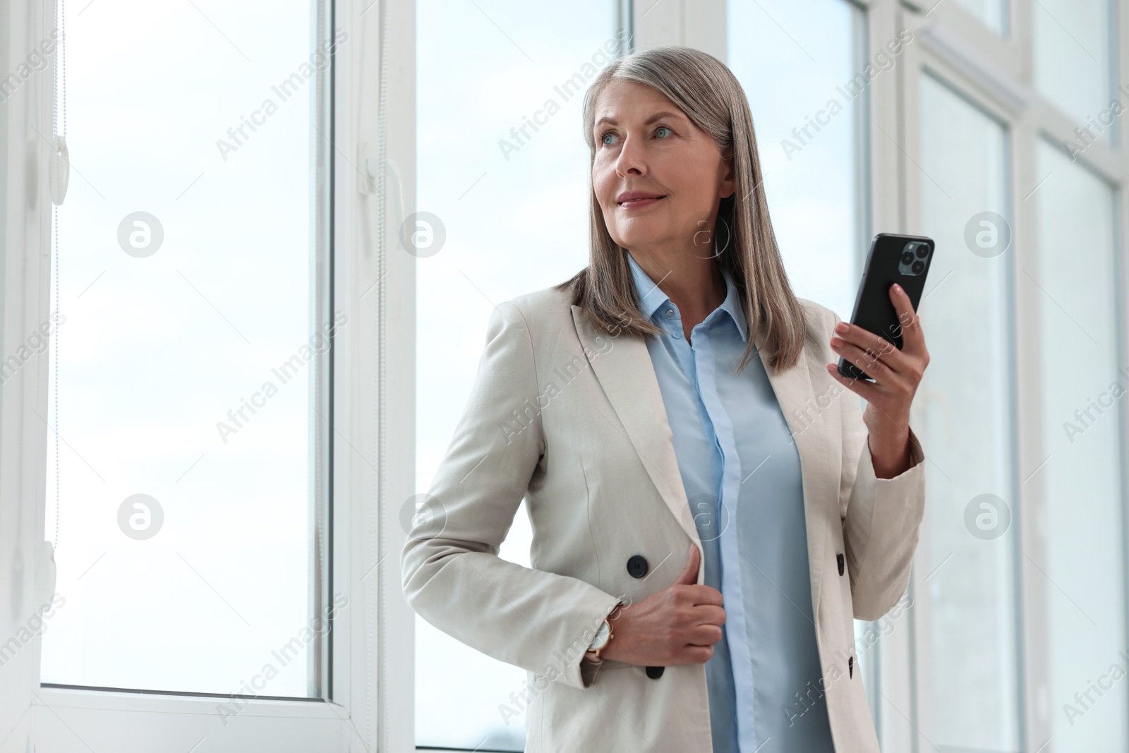 Photo of Senior woman using mobile phone at home