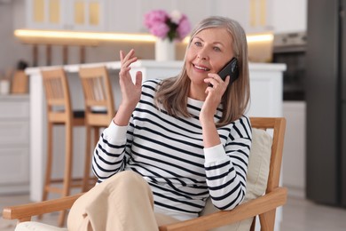 Senior woman talking on phone at home