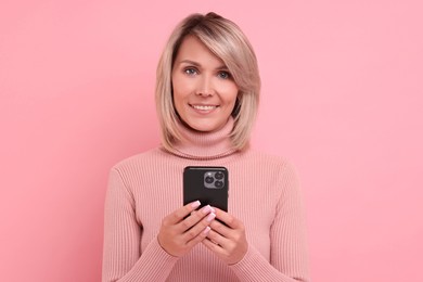 Photo of Happy woman with phone on pink background