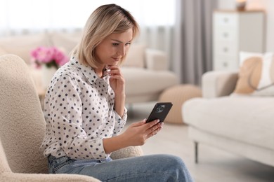 Photo of Woman using mobile phone at home, space for text