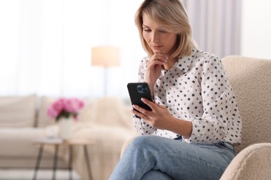 Photo of Woman using mobile phone at home, space for text
