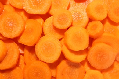 Slices of fresh ripe carrot as background, top view