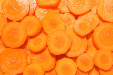 Slices of fresh ripe carrot as background, top view