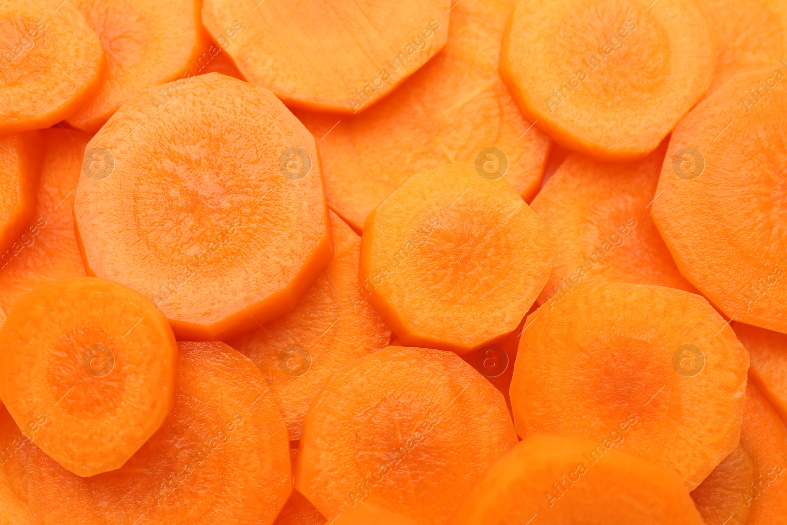 Photo of Slices of fresh ripe carrot as background, top view