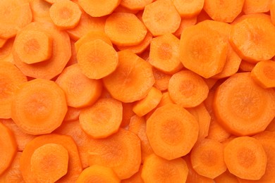 Slices of fresh ripe carrot as background, top view