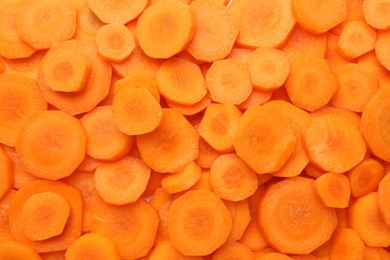 Slices of fresh ripe carrot as background, top view