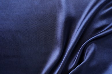 Photo of Crumpled dark blue silk fabric as background, top view. Space for text