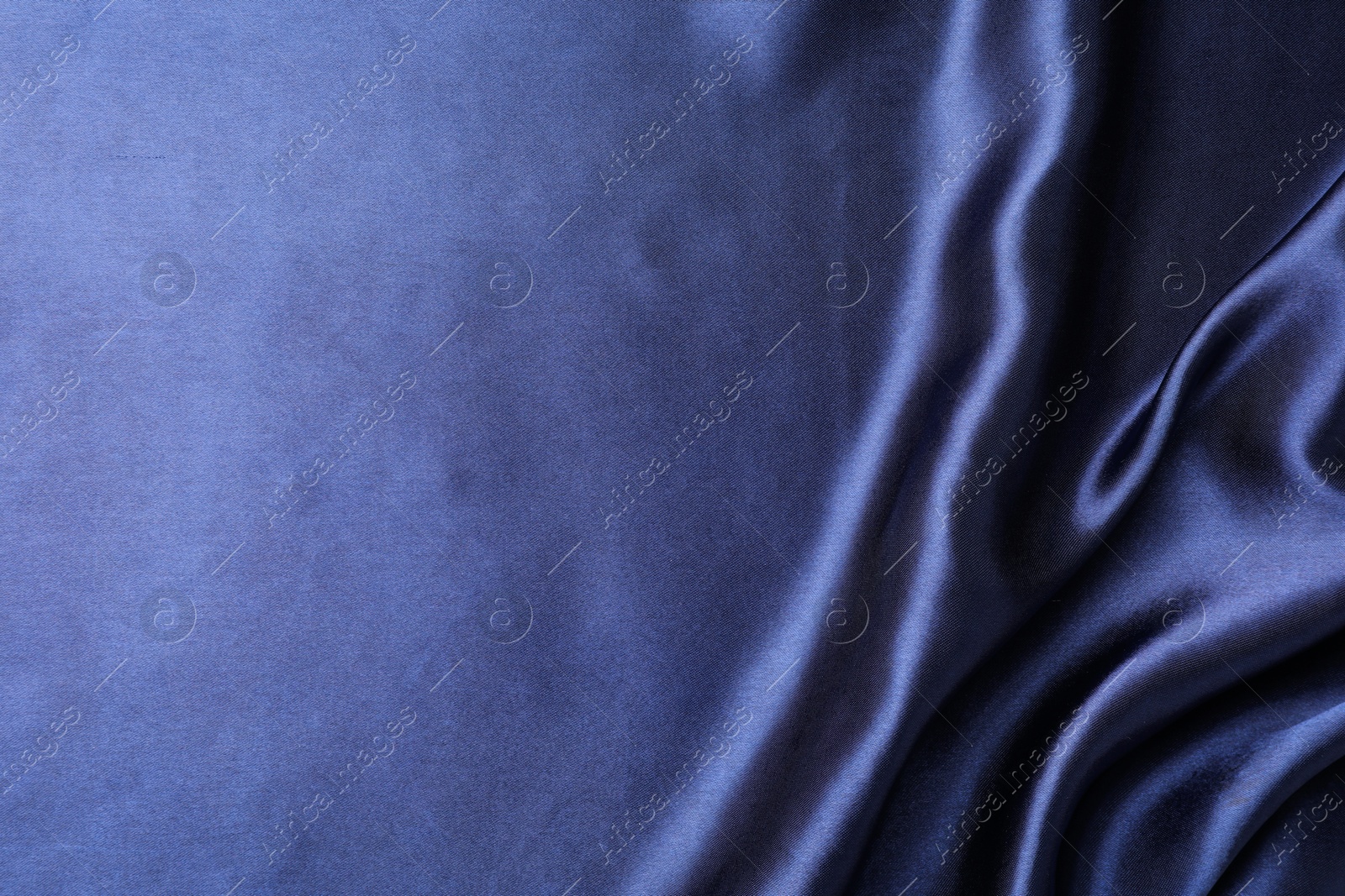 Photo of Crumpled dark blue silk fabric as background, closeup. Space for text