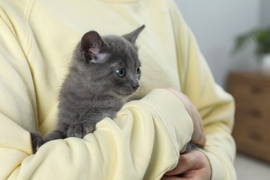 Photo of Woman with cute fluffy kitten at home, closeup