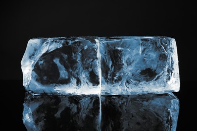 Photo of Blocks of clear ice on black mirror surface