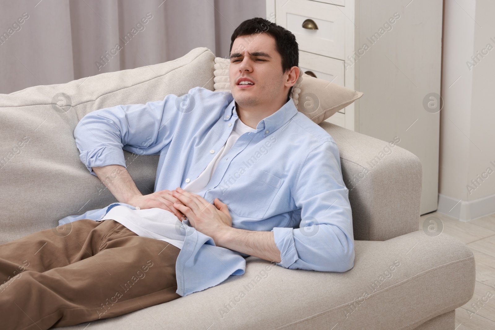 Photo of Man suffering from abdominal pain at home