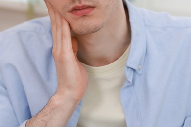 Photo of Man suffering from toothache at home, closeup